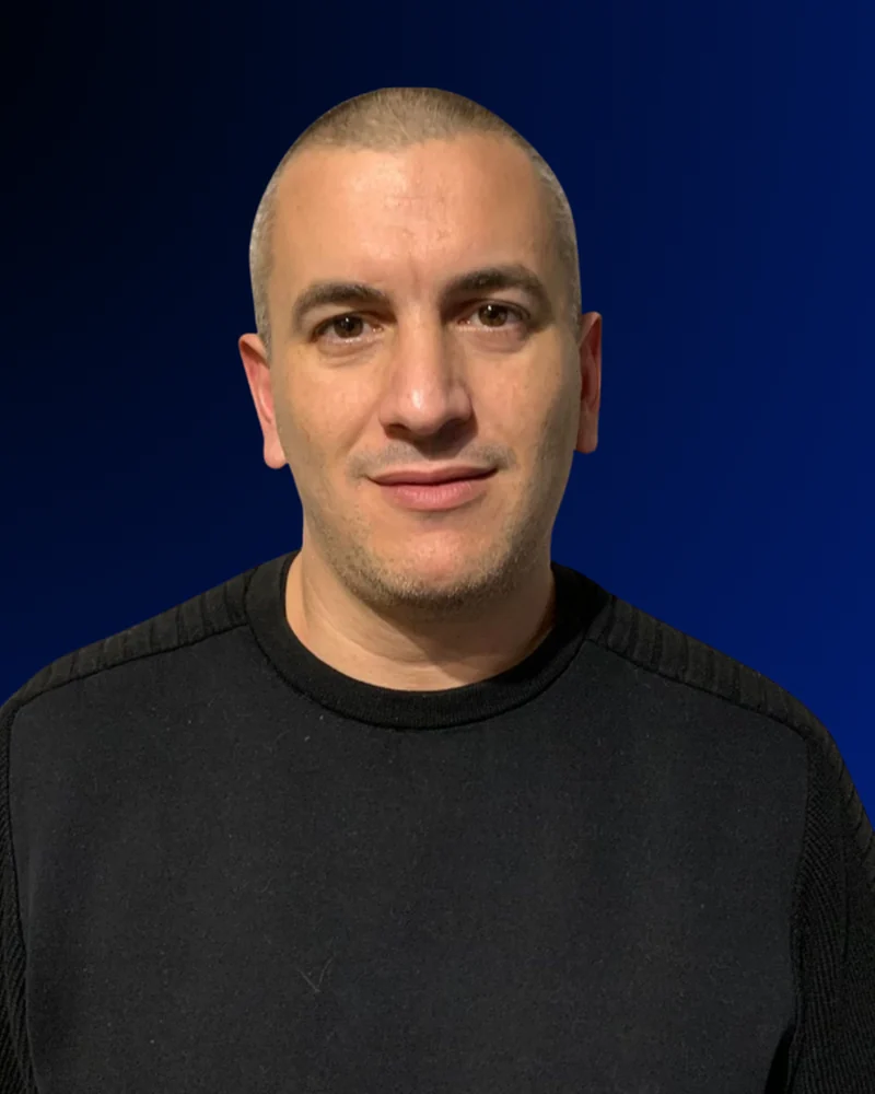 Gustavo Luis Sánchez, de frente, con jersey negro sobre fondo azul